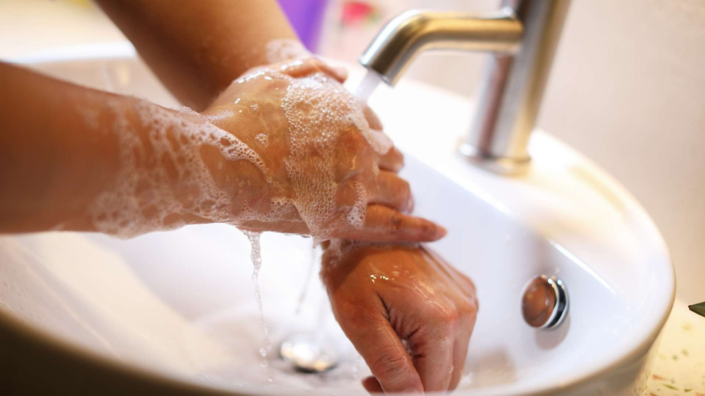 Hands being washed with soap and running water to prevent the spread of germs.