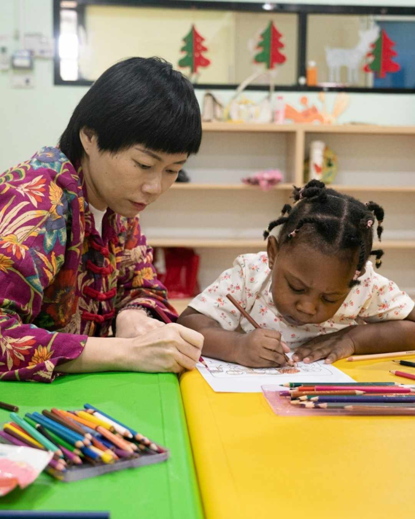 ary Margaret Daycare and Learning Center before and after school child drawing with teacher support