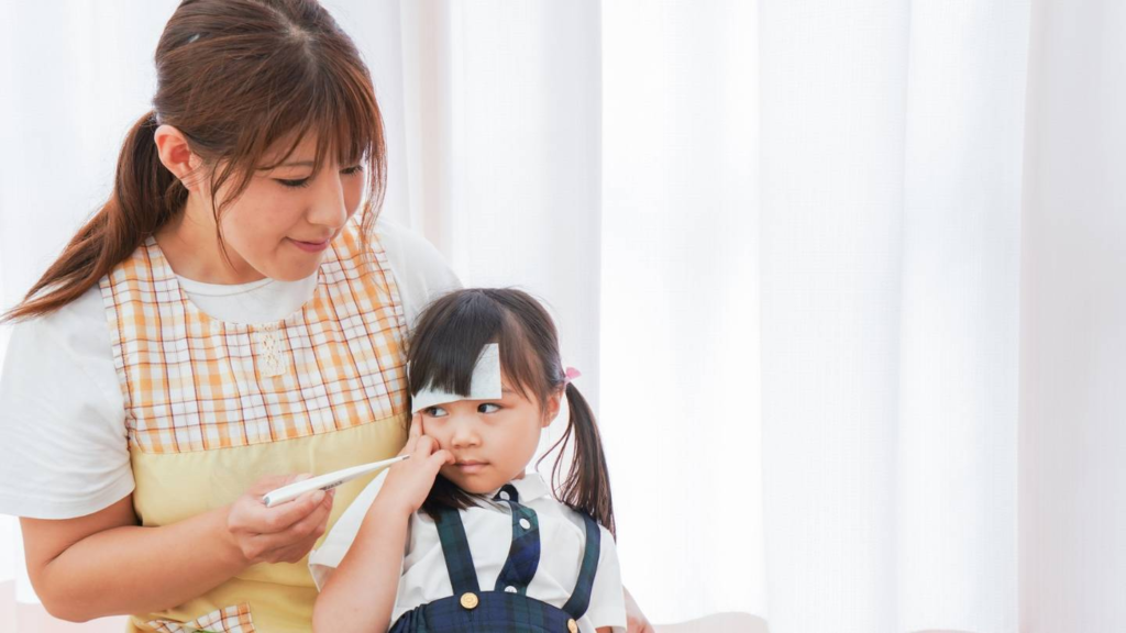 Caregiver checking a young child’s temperature while offering comfort and support.
