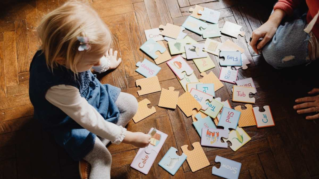 Toddler playing with picture and word puzzle pieces during an early language activity.