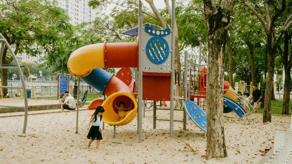 Young children playing on a colorful playground during outdoor playtime.