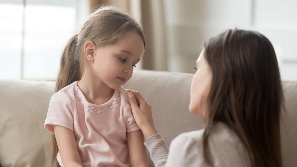 Mother comforting her young daughter during a quiet conversation at home.